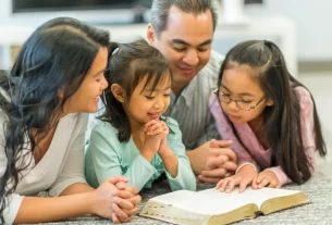 família reunida lendo a Bíblia para mostrar como ensinar os filhos sobre a páscoa