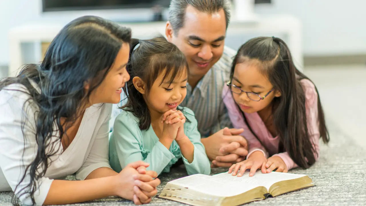 família reunida lendo a Bíblia para mostrar como ensinar os filhos sobre a páscoa