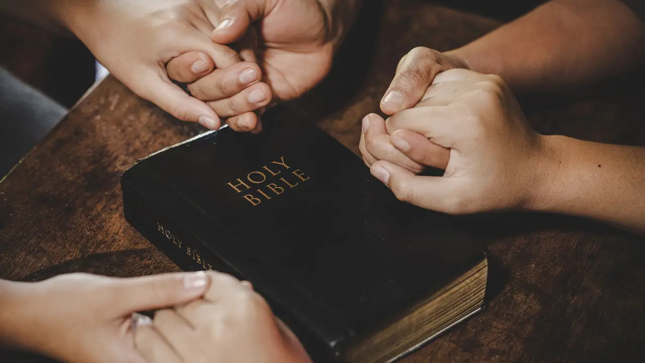 mãos unidas em um grupo de oração feminino