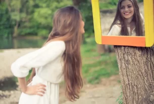 Beleza que Deus vê representada por uma mulher vendo seu reflexo no espelho