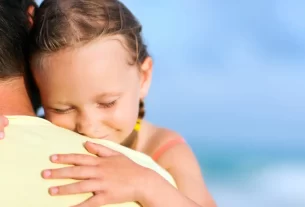 presença paterna simbolizada por uma menina abraçada ao pai.