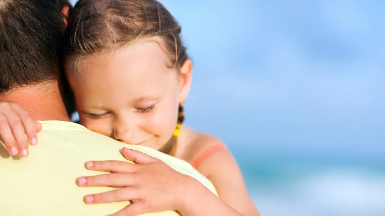 presença paterna simbolizada por uma menina abraçada ao pai.