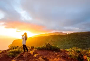 Uma mulher olhando o nascer do sol para simbolizar que a vida é dom de Deus