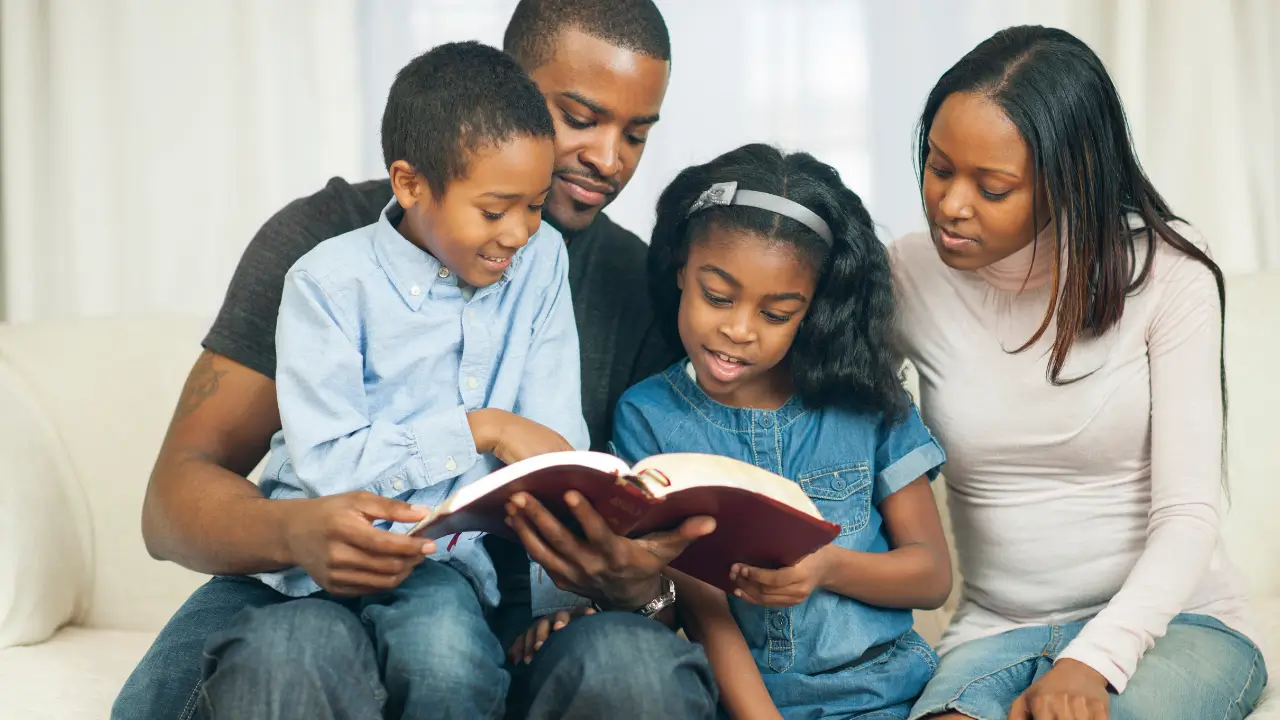 Família reunida lendo a Bíblia para simbolizar que desde a infância precisa ensinar sobre fé.
