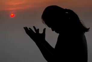 Uma mulher com as mãos em posição de oração e contrição , simbolizando a fé da mulher de Suném.