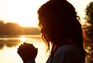 Uma mulher em posição de oração para simbolizar que quando não há forças, existe a graça de Deus.