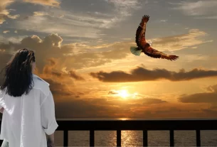 uma mulher plhando o nascer do sol e uma águia voando, simbolizando recomeços da esperança