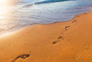 Devocional para consagrar o ano a Deus ilustrado através de passos na areia na beira do mar