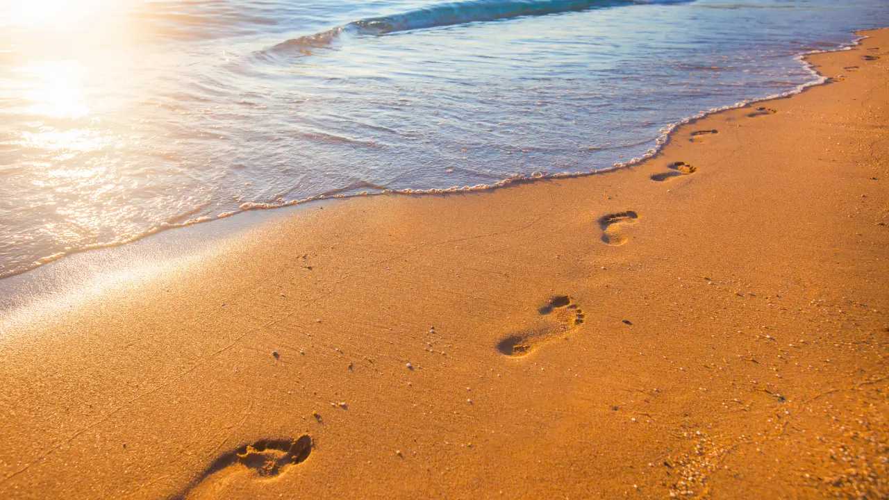 Devocional para consagrar o ano a Deus ilustrado através de passos na areia na beira do mar