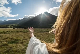 Deus faz novas todas as coisas simbolizado por uma mulher com mãos estendidas no horizonte