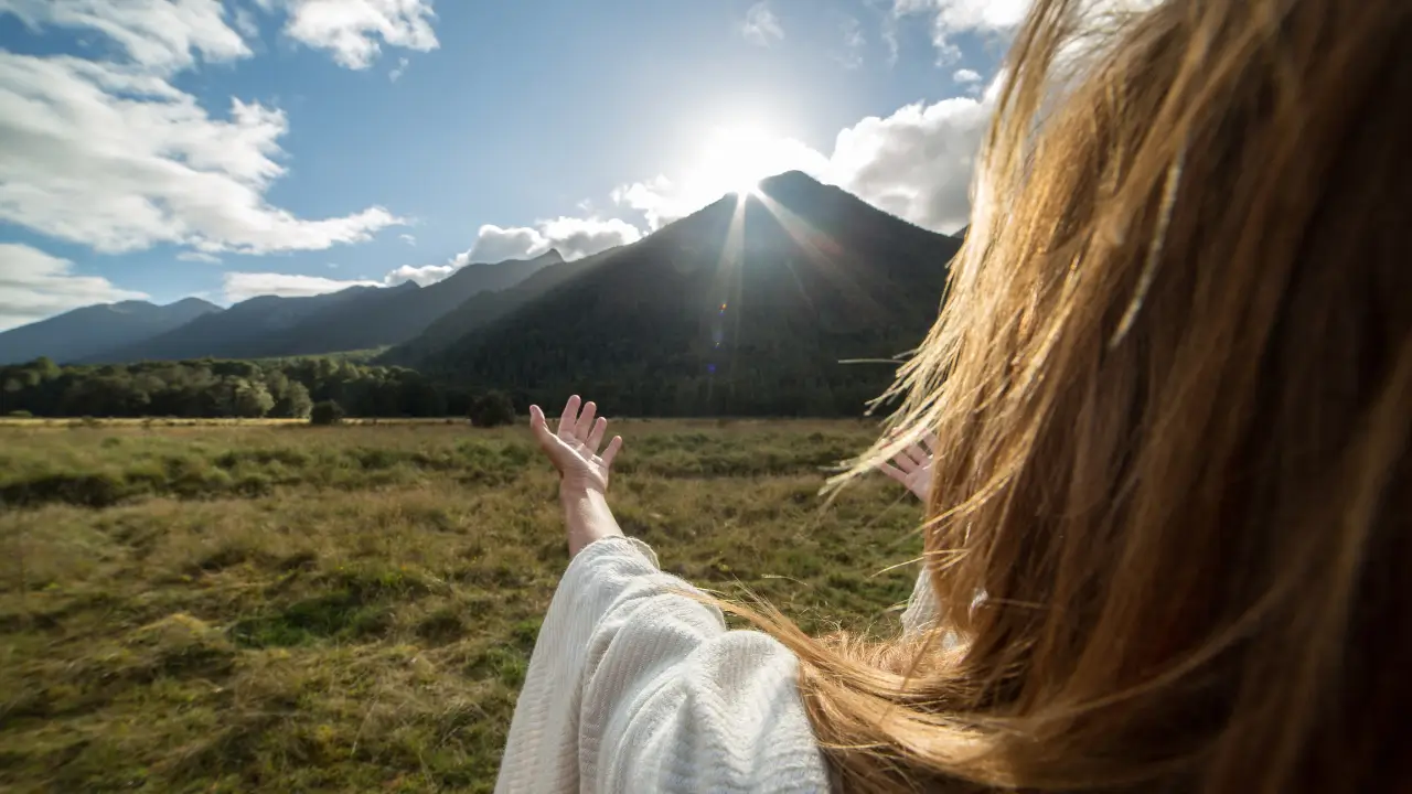 Deus faz novas todas as coisas simbolizado por uma mulher com mãos estendidas no horizonte