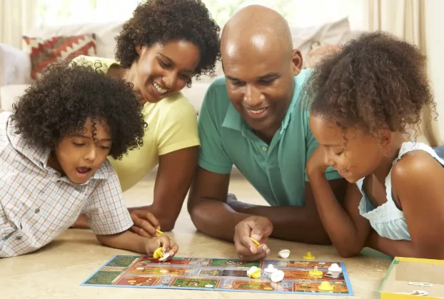 Casal com dois filhos brincando para simbolizar um lar espiritualmente saudável