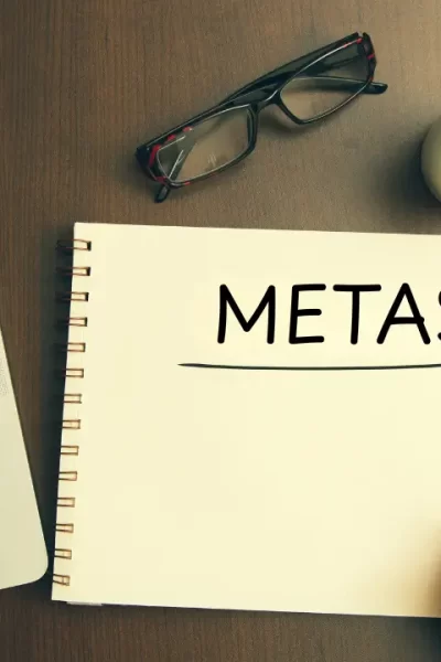 um caderno de anotações em uma mesa e alguém escrevendo a palavra metas espirituais