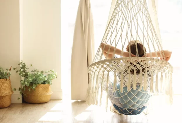 uma mulher em uma rede na sala para simbolizar a lida com os conflitos familiares através da fé