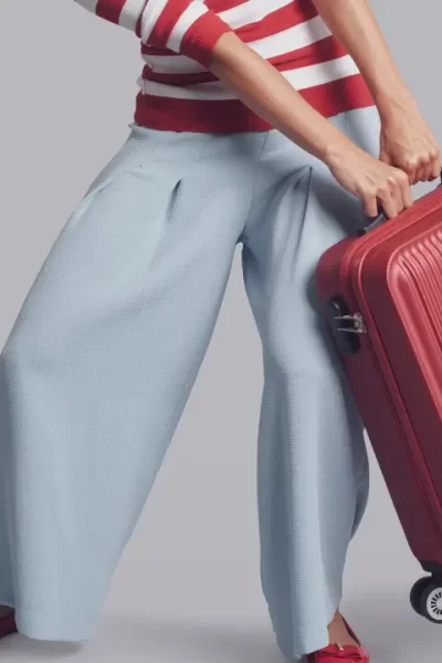 mulher puxando uma mala com dificuldade para mostrar que carrega um peso que não é seu.