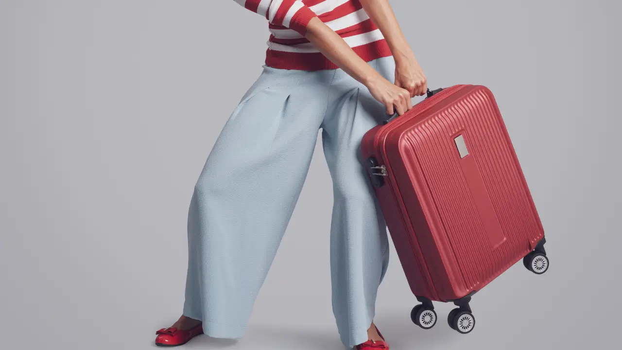 mulher puxando uma mala com dificuldade para mostrar que carrega um peso que não é seu.